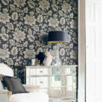 Interior of chair in room with mirrored cabinet against floral pattern wallpaper