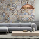 Interior with large blue vibrant sofa with coffee table, large pendant light above, tiles on the wall, with shelf and flowers, carpet. concrete wall, designer template. horizontal composition